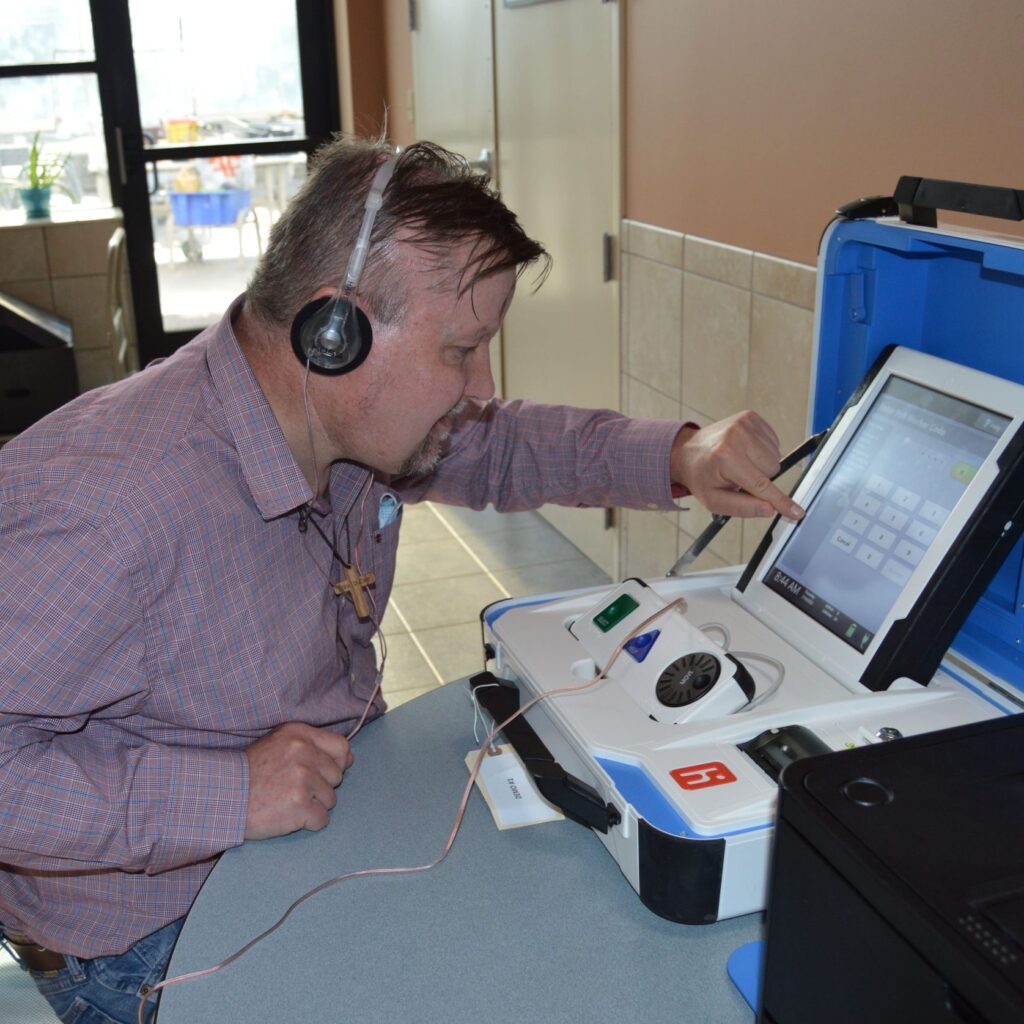 client practicing with accessible voting machine