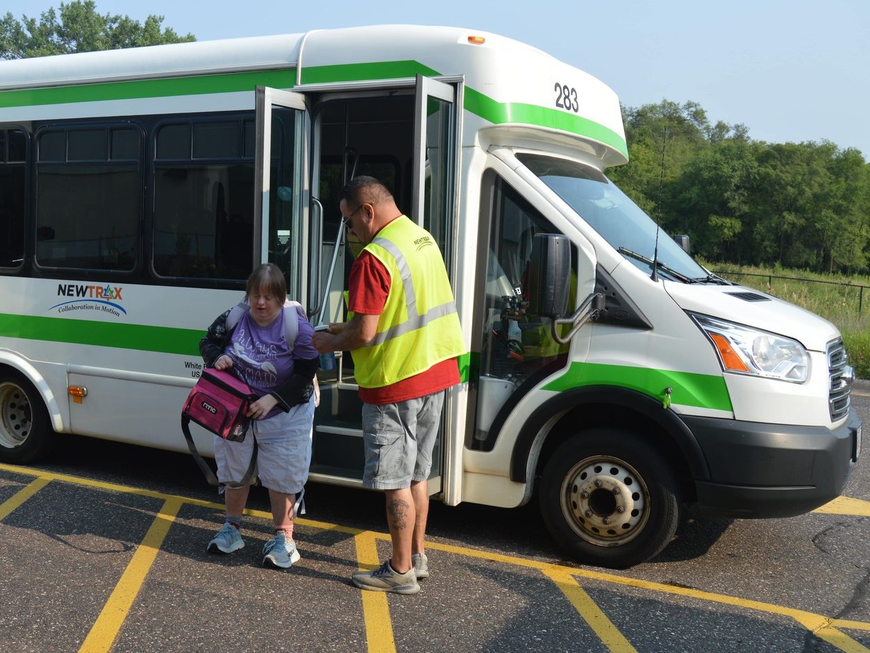driver assists clients as they exit Newtrax bus