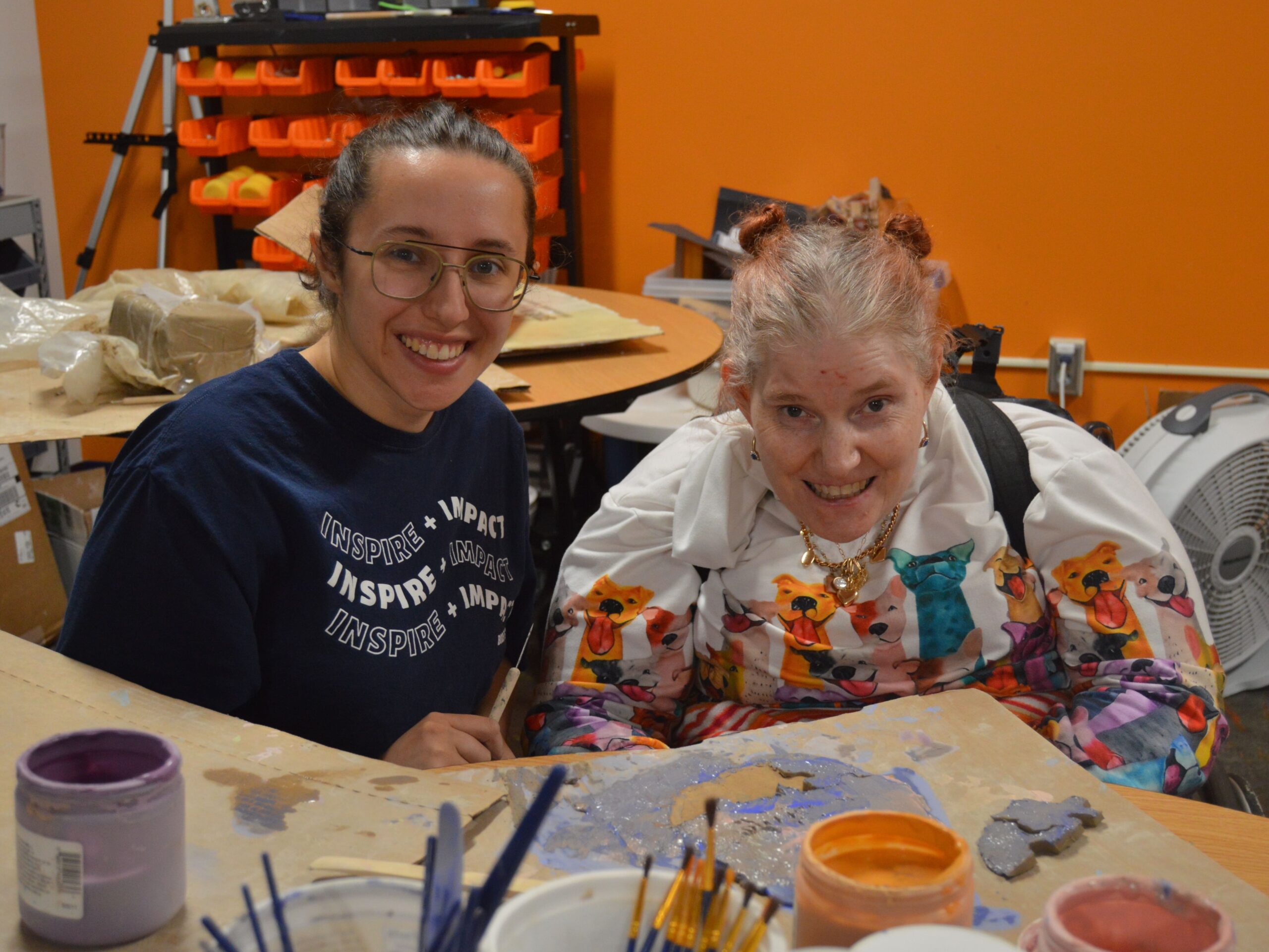 client and staff painting a pottery piece